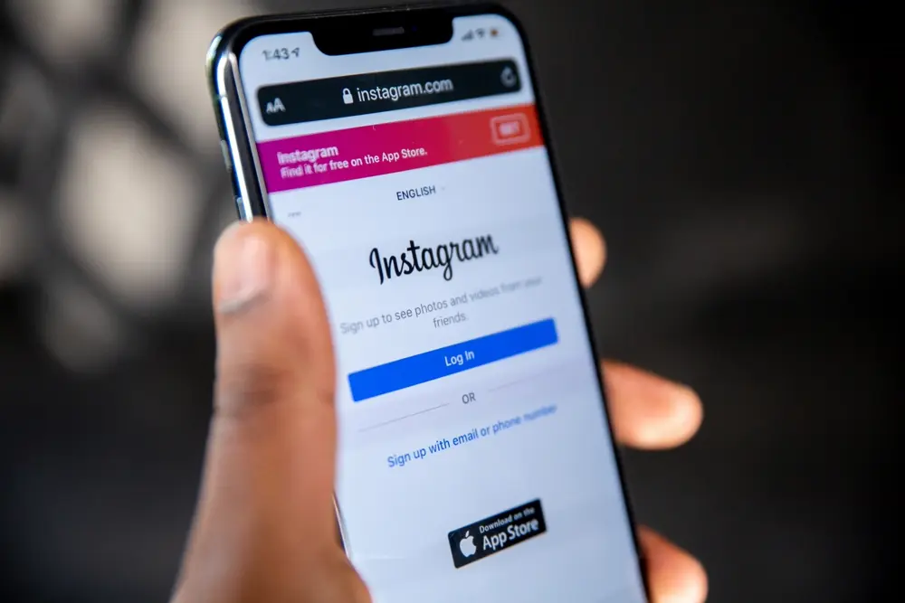 Persona sosteniendo un teléfono con la app de Instagram abierta, ilustrando comprar seguidores en Instagram