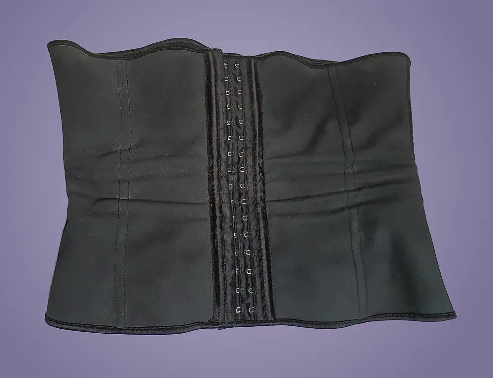 Cinturilla negra tipo waist trainer sobre fondo neutro, referencia al nicho de corsetería en Instagram Chile