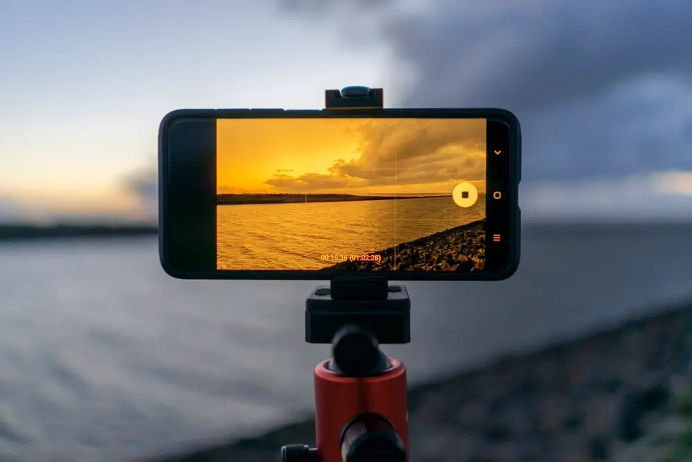Persona grabando un video con el celular sobre un trípode, referencia al contenido de humor en redes sociales en Chile