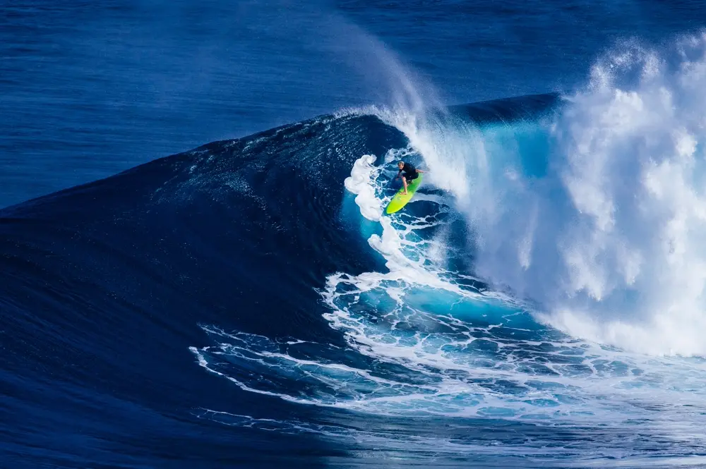 Deportista de tabla sobre una gran ola azul, referencia al contenido de bodyboard en Instagram Chile