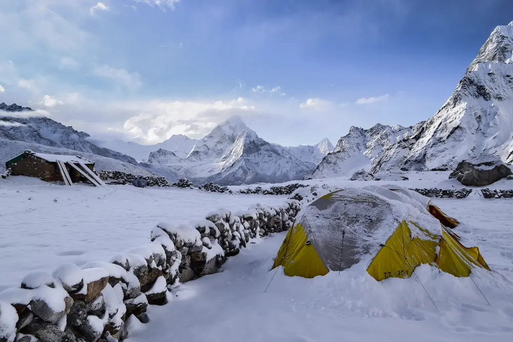 Carpa de montaña cubierta de nieve frente a cumbres nevadas, referencia al contenido de montañismo y outdoor en Instagram Chile