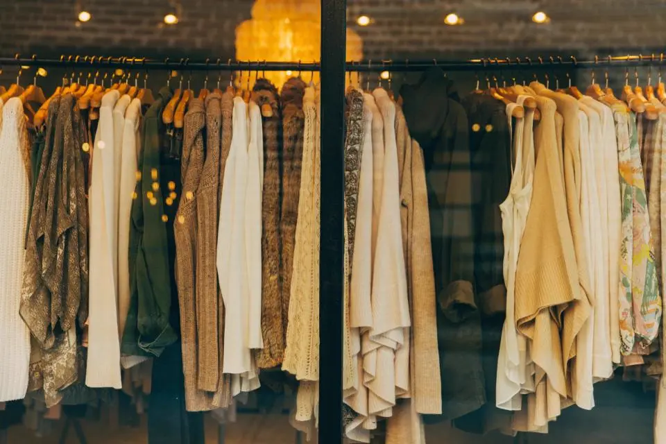 Percha con chalecos y prendas en tonos tierra en una tienda de ropa, referencia al contenido de outfits y lifestyle en Instagram Chile