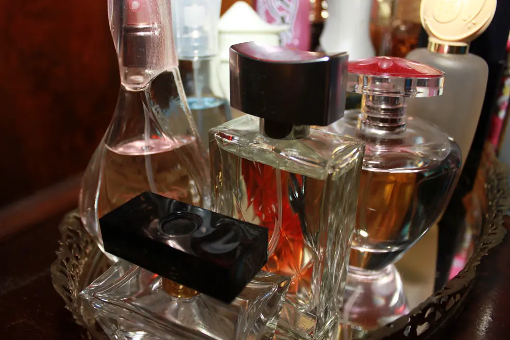 Frascos de perfume sobre una bandeja espejada, referencia al contenido de fragancias y skincare en Instagram Chile