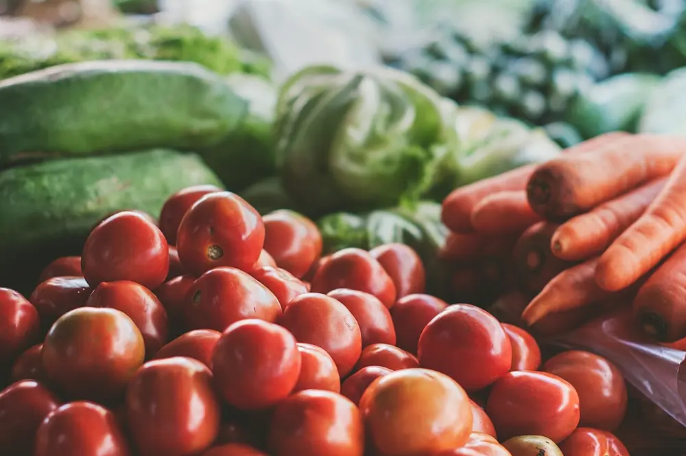 Tomates, zanahorias y verduras frescas en un mercado, referencia al contenido de nutrición en Instagram Chile
