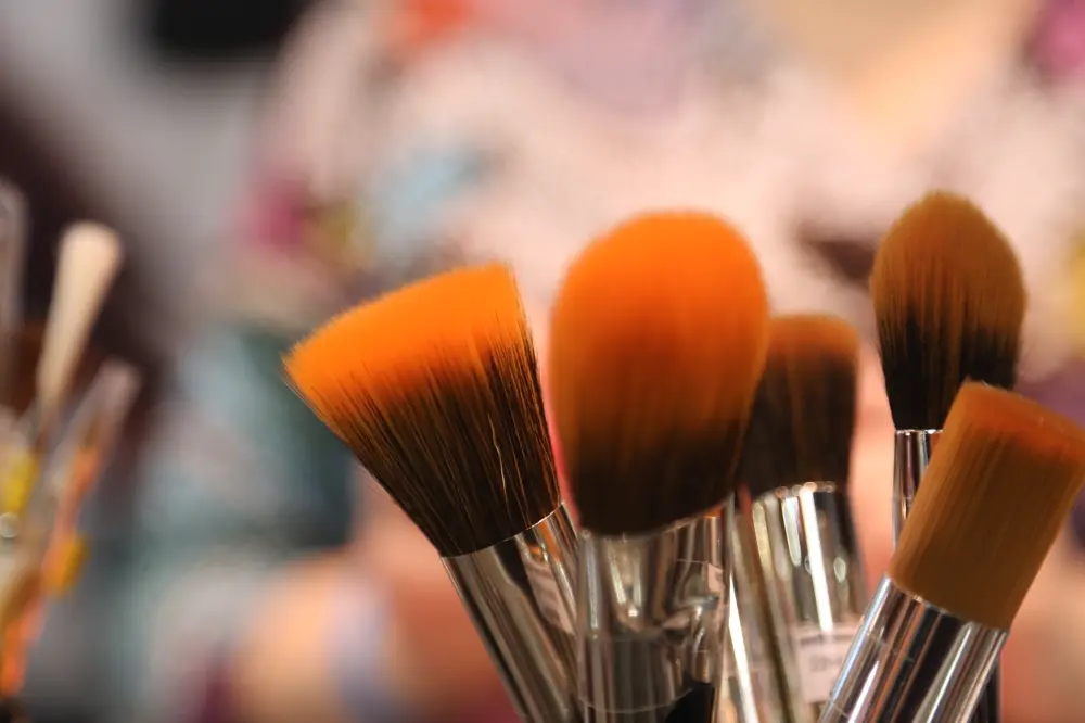 Brochas de maquillaje de cerdas naranjas en primer plano, referencia al contenido de belleza y skincare en Instagram Chile