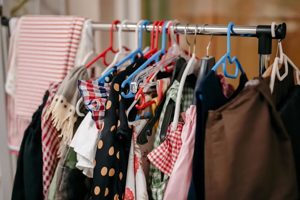Perchero con ropa colgada de colores y estampados, referencia al contenido de moda en Instagram Chile